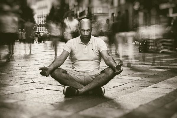 Hombre en postura de meditación en plena calle