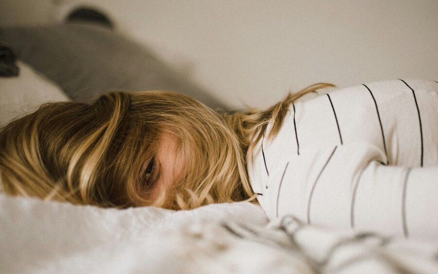 Chica en una cama en actitud de querer dormir