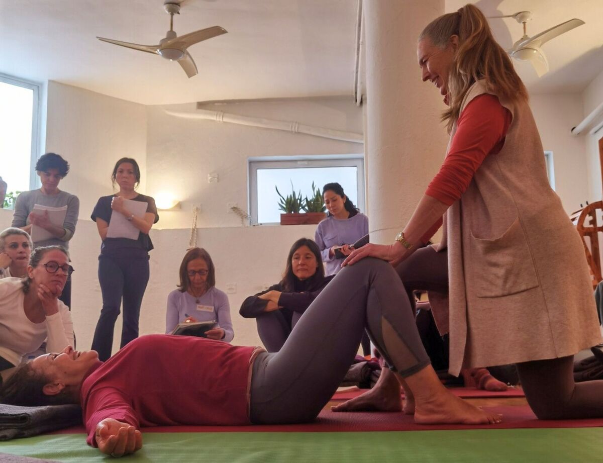 Lisa Petersen ajustando a una alumna en su formación de Movimiento somático en City Yoga