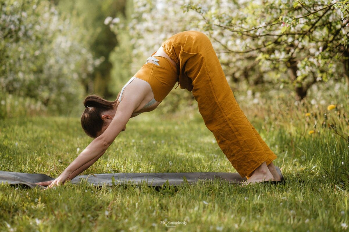 Chica en la famosa postura de yoga perro boca abajo.