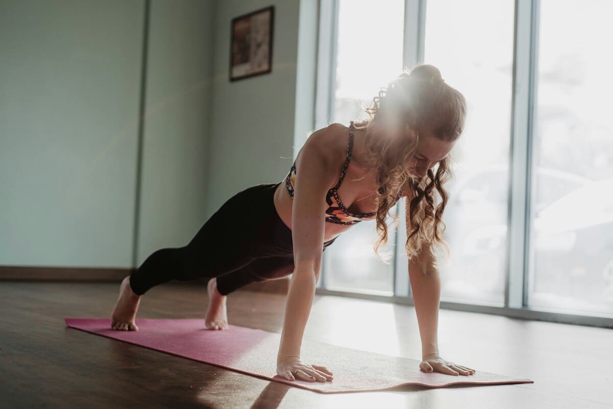 Chica haciendo una plancha abdominal isométrica.